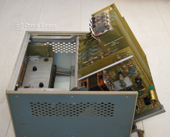 
     The card cage hinged upwards, releasing the circuit boards.
     